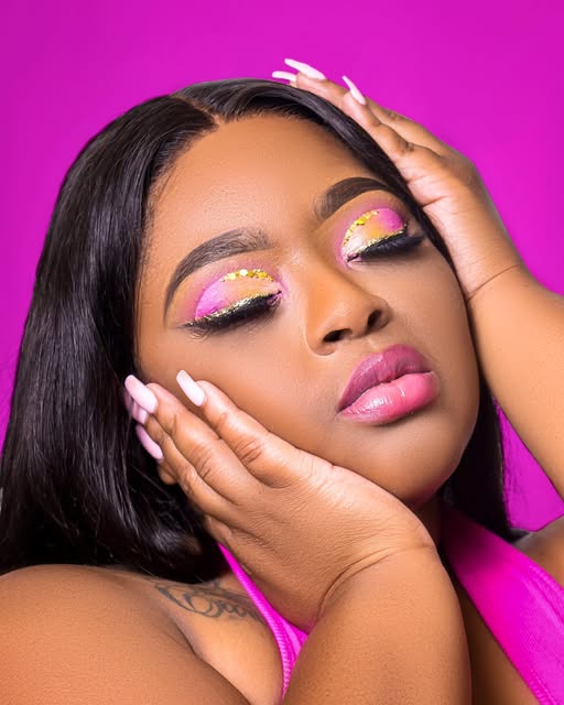 Beauty portrait with pink makeup against a magenta background.